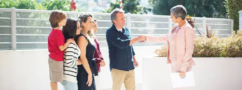 Real Estate Agent Insurance in WA - Image of a real estate agent shaking hands with a family